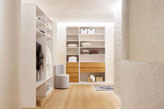 Heller Flur mit modernen Regalen und einem minimalistischen Holzschrank.