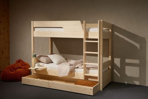 Hochbett aus Holz mit unterem Bett, Kissen und einer Leiter, in einem minimalistischen Raum.