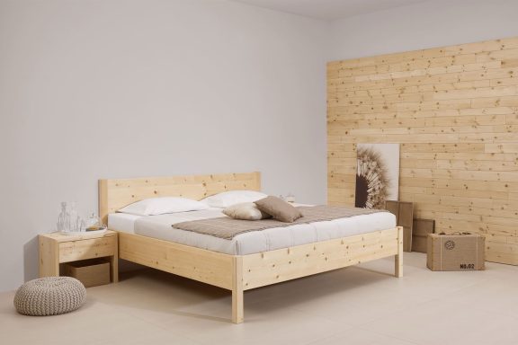 Minimalist Schlafzimmer mit einem Holzbett, einer Nachttisch und dekorativen Elementen.